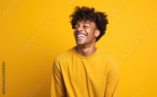 Photo of young male smiling and laughing on bright yellow background © steffenak