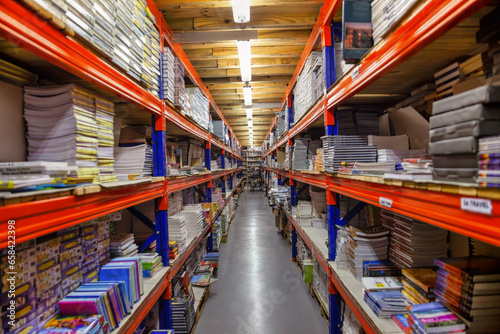 heavy duty shelves in a warehouse filled with books and paper rims for school and stationary supply, back to school