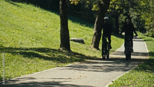 Wallpaper Mural Young Couple Rides a Bicycle in the Park Without Pedaling. Concept of Healthy lifestyle, Spring or Summer Activity, Happy Relationship, Active Life, Bonding, Weekend Activity, Recreation, Leisure Torontodigital.ca