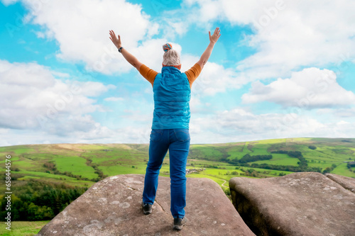 Woman  reaching the destination and taking selfie, photos,  and shouting on the top of mountain  Travel Lifestyle concept The national park Peak District in England photo