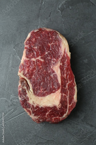 Piece of raw beef meat on grey table, top view