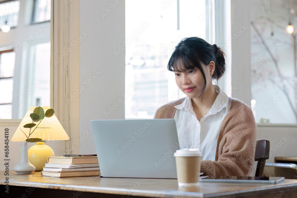 Asian female student studying online, studying on a video call, zoom call, passionate Asian female teacher learning English online with a laptop computer Asian female student studying online, studying on a video call, zoom call, passionate Asian female teacher learning English online with a laptop computer
