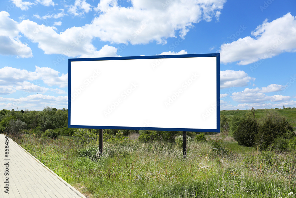 Empty signboard near road outdoors. Mock-up for design Empty signboard near road outdoors. Mock-up for design