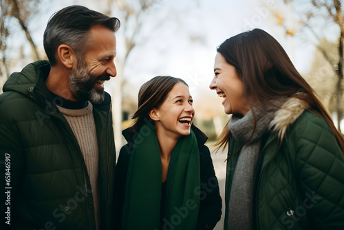Happy family couple with teen daughter having fun talking to parents, smiling daughter enjoy loving family