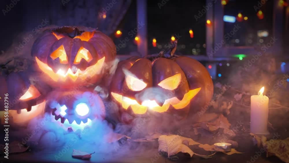 Halloween background with Jack O Lanterns with flashing light inside, smoke and pumpkins on a black background. Festival holiday during Halloween party decoration. Halloween background with Jack O Lanterns with flashing light inside, smoke and pumpkins on a black background. Festival holiday during Halloween party decoration.