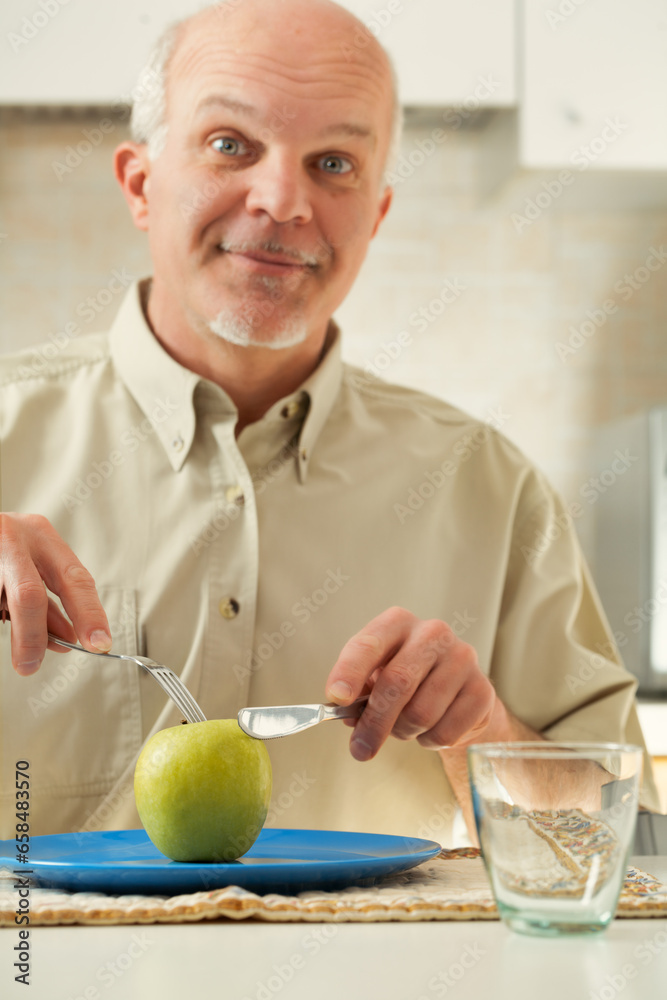 Fototapeta premium Elder with apple, yearns for indulgent meals