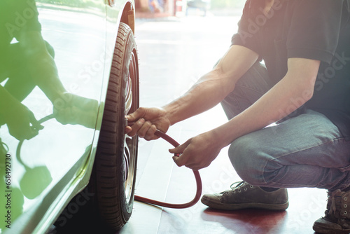 Filling air into a car tire at service center photo