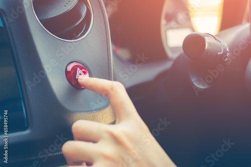 Foto Finger hitting car emergency red light button in the car.