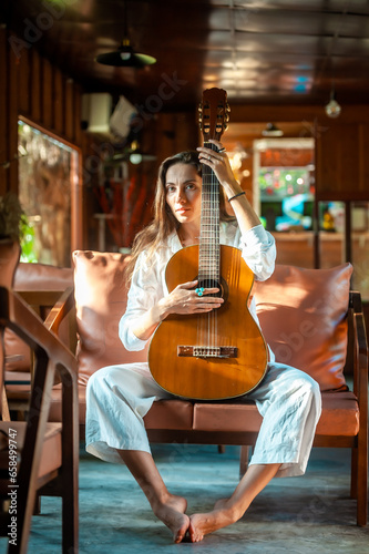 woman okaying posing with guitar in restaurant cafe © RobWest