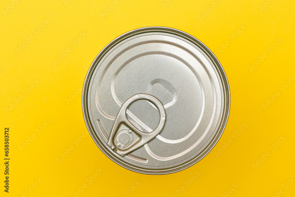Unopened Tin Can with Blank Edge on Yellow Background. Canned Food