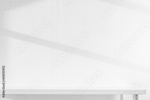 Empty white desk with morning light and shadows of windows with copy space, summer concert. Blurred backdrop abstract background for display product.