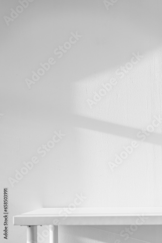 Fototapeta Naklejka Na Ścianę i Meble -  Empty white desk with morning light and shadows of windows with copy space, summer concert. Blurred backdrop abstract background for display product.