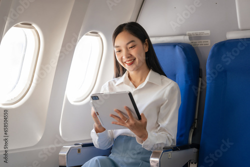 Using tablet pc  Thoughtful asian people female person onboard  airplane window  perfectly capture the anticipation and excitement of holiday travel. chinese  japanese people.