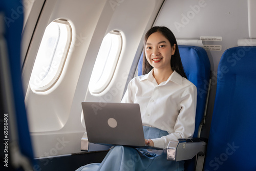 Using laptop computer, Thoughtful asian people female person onboard, airplane window, perfectly capture the anticipation and excitement of holiday travel. chinese, japanese people.
