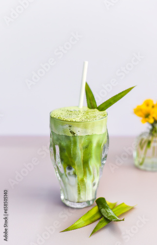 blended brew matcha latte with straw on light gray background