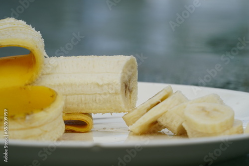 Peeled and sliced yellow Banana sits on a plate ready to be eaten.