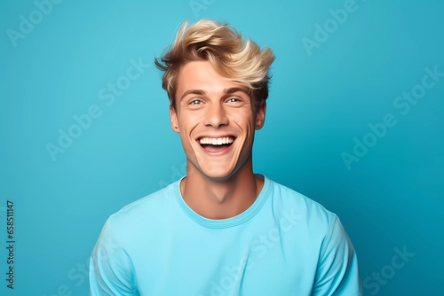 Radiant Blond Man with Blue Eyes Laughing in Bright Blue Apparel Against Solid Blue Background