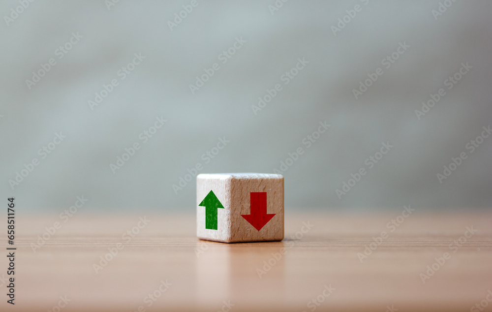Rising and falling trends. green up arrow in bright side and red down arrow in dark side which print screen on wooden cube block for economic and business profit growth concept. Rising and falling trends. green up arrow in bright side and red down arrow in dark side which print screen on wooden cube block for economic and business profit growth concept.