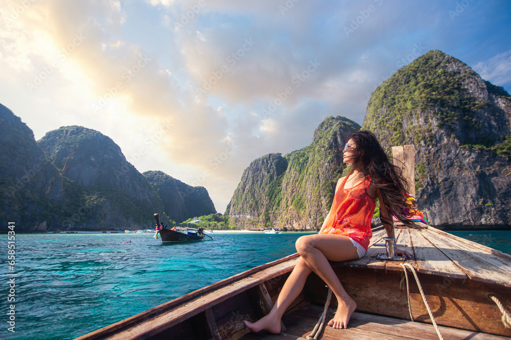 Asian travel woman relax on the traditional long tail boat with maya bay