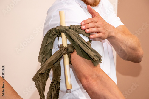 A health worker demonstrates how to apply a bandage to the arm to stop bleeding in the absence of a tourniquet photo