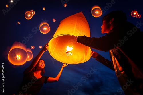 Foto Asian couple traveller setting yi peng  lantern in loi krathong festivities