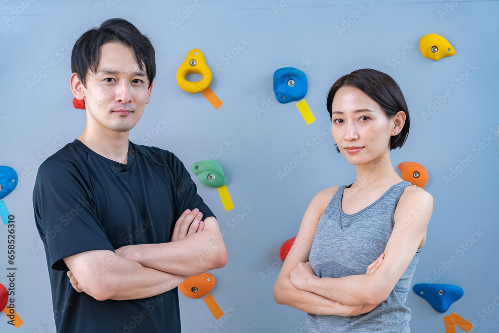 クライミングウォールの前でポーズをとる2人