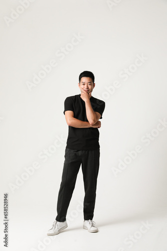 Handsome young Asian man posing isolated indoor. Vertical mock-up.