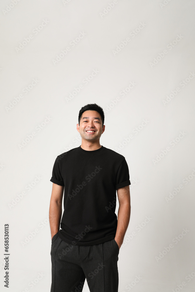 Smiling handsome Asian young man posing over white background wearing black clothing. Smiling handsome Asian young man posing over white background wearing black clothing.