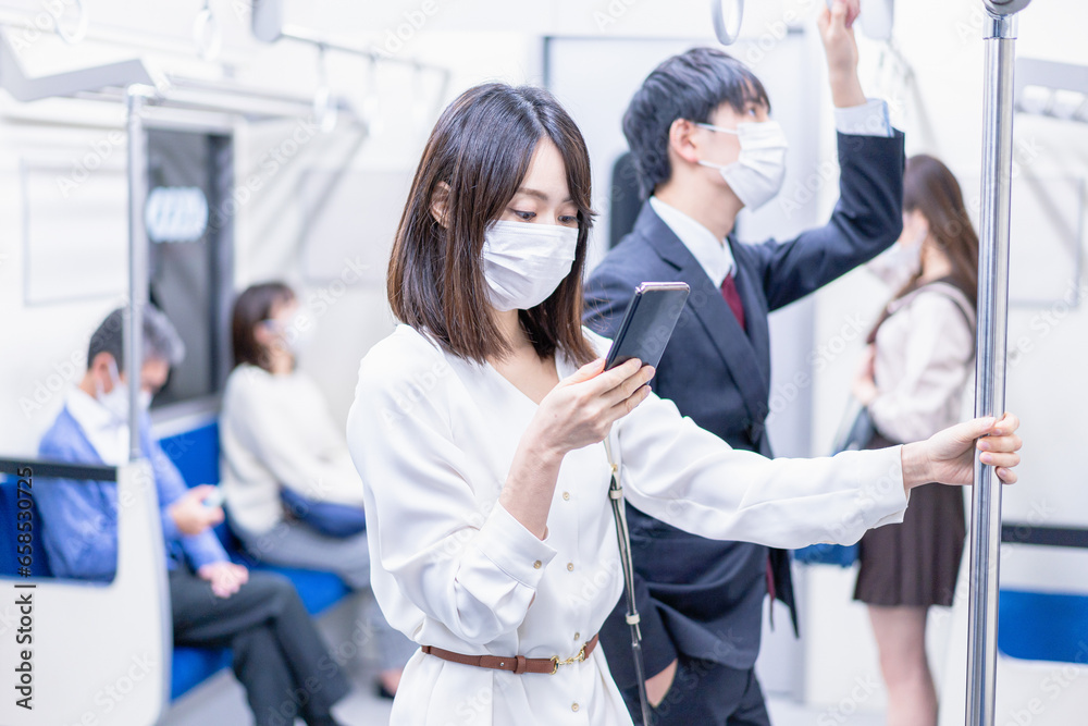 マスクをして電車移動をする若い女性 マスクをして電車移動をする若い女性