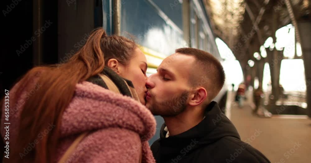 A young couple in love hug and say goodbye before the girl gets on the train to leave. Farewell at the station.