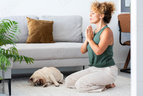 One young adult woman doing yoga exercises at home alone in living room. Healthy workout pilates lifestyle people in indoor sport activity. Wellbeing and interior mental balance mindful female mature