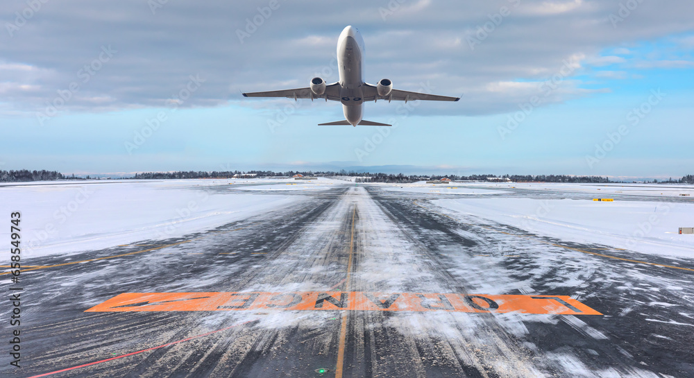 Commercical white airplane fly up over take-off runway the (ice) snow-covered airport- Norway - obrazy, fototapety, plakaty 