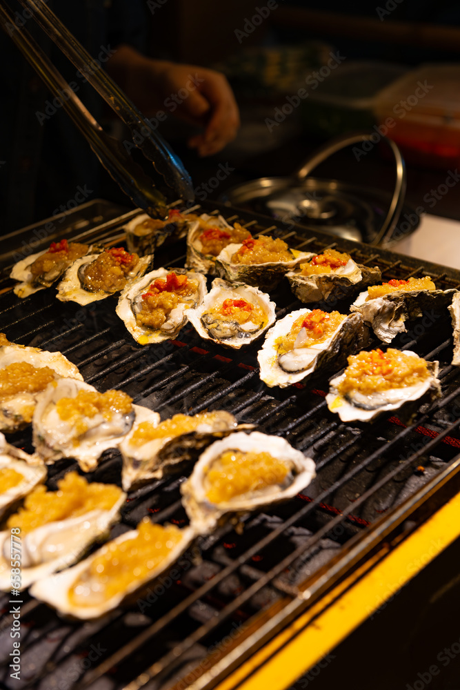 cooking charcoal grilled oysters with garlic sauce at vertical composition cooking charcoal grilled oysters with garlic sauce at vertical composition