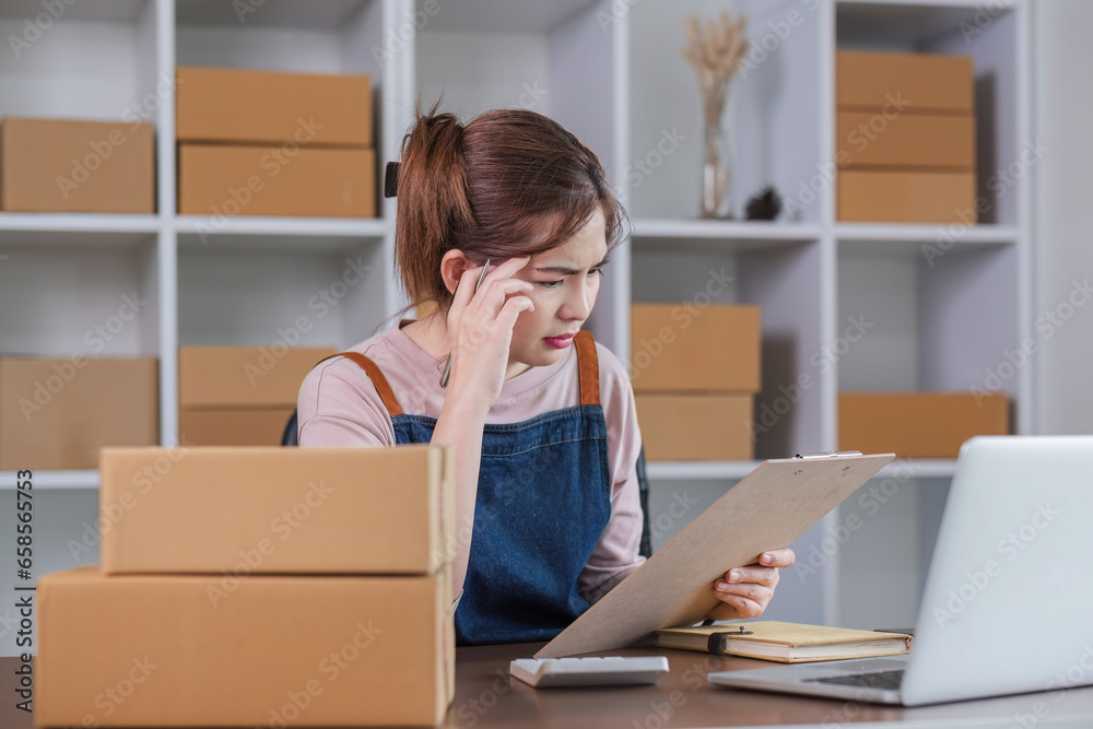 Asian woman think hard serious working laptop computer at home selling online start up small business owner, e-commerce ideas concept.