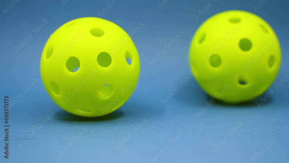 Close up of 2 pickleball balls on court Close up of 2 pickleball balls on court