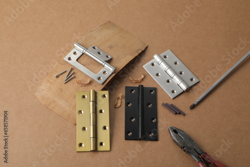 Installation of furniture hinges in chipboard. Small carpentry work in the workshop. light background,Installation of furniture hinges in chipboard in the workshop.dark background