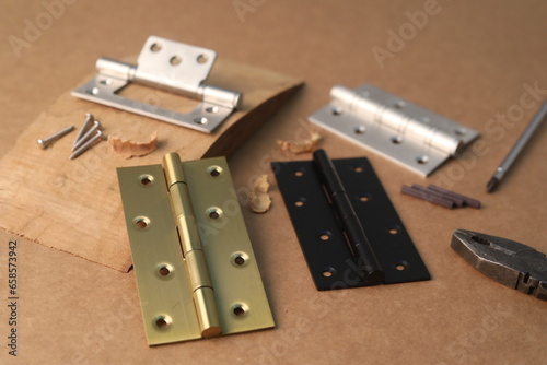 Installation of furniture hinges in chipboard. Small carpentry work in the workshop. light background,Installation of furniture hinges in chipboard in the workshop.dark background