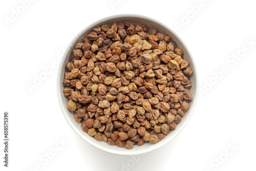 Black organic Chickpeas ( Cicer arietinum) or Kala Chana in a white ceramic bowl. Isolated on a white background. Top View