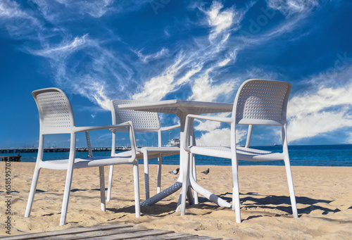 White chairs and table on the sandy beach