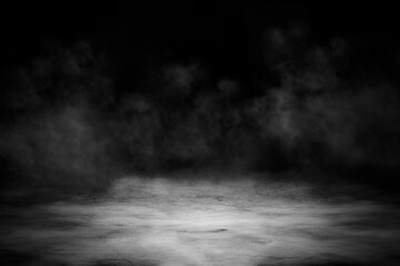 Concrete floor with smoke or fog in dark room with spotlight. Asphalt night street, black background, black and white