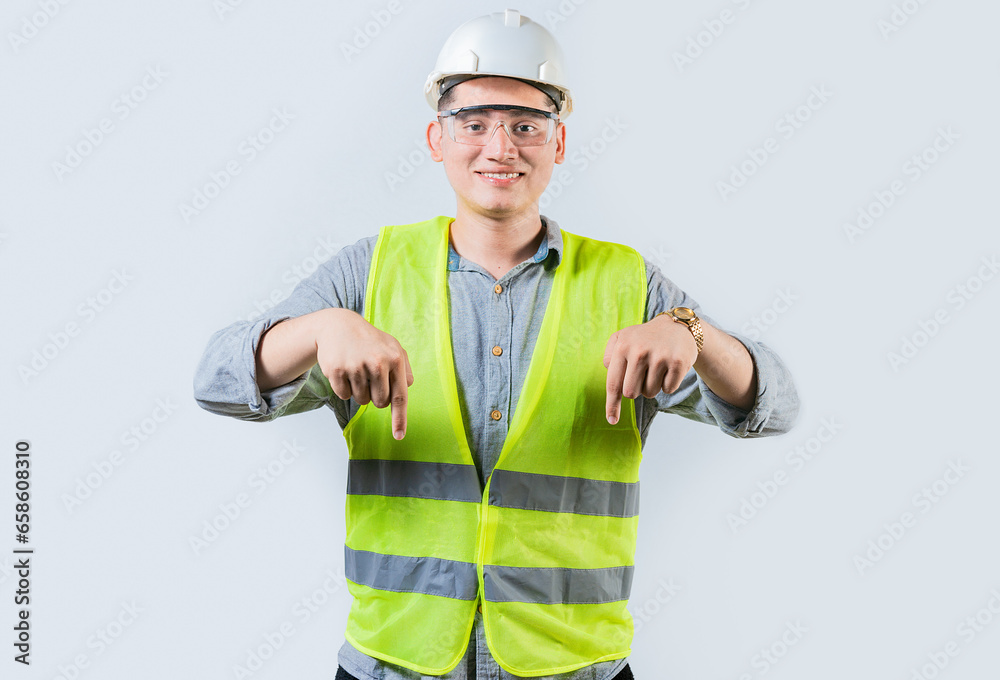 Smiling engineer pointing advertising down isolated. Smiling friendly engineer pointing down isolated Smiling engineer pointing advertising down isolated. Smiling friendly engineer pointing down isolated
