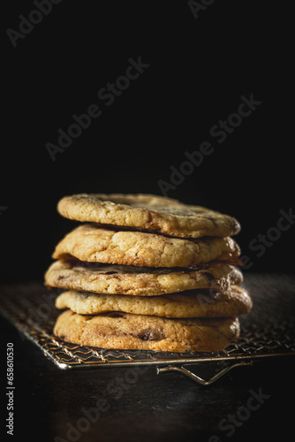 ein Stapel selbstgemachte, hausgemachte Cookies auf Gitterrost. Lecker, frisch, köstlich, appetitlich, vor dunklem Hintergrund im Hochformat