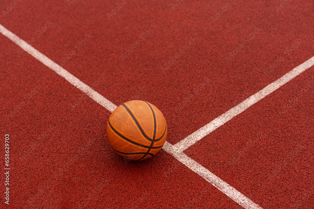 Orange basketball on brown court of gymnasium sport floor. Street basketball concept Orange basketball on brown court of gymnasium sport floor. Street basketball concept