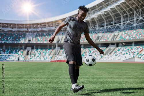 Professional football player in action at the stadium. The concept of sport, competition, movement, overcoming. The effect of the presence of the field. © Katsiaryna