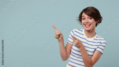 Young woman wear striped t-shirt casual clothes point index finger camera on you aside indicate index finger aside on workspace area copy space mock up isolated on pastel plain blue cyan background