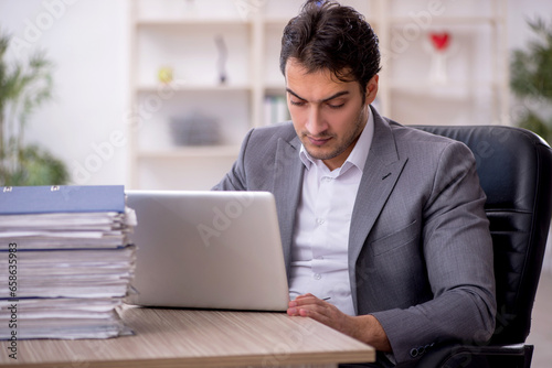 Young male employee and too much work in the office