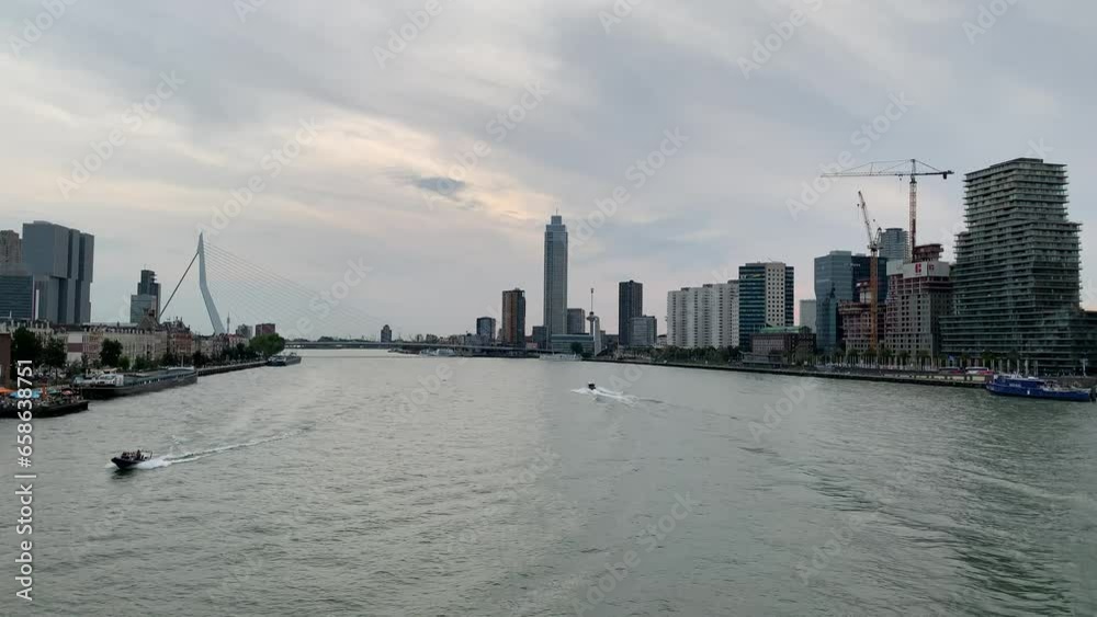 Skyline of Rotterdam city centre, downtown. High rise buildings and famous Erasmus bridge. Speed boats are moving across the river. Rotterdam, Netherlands Skyline of Rotterdam city centre, downtown. High rise buildings and famous Erasmus bridge. Speed boats are moving across the river. Rotterdam, Netherlands