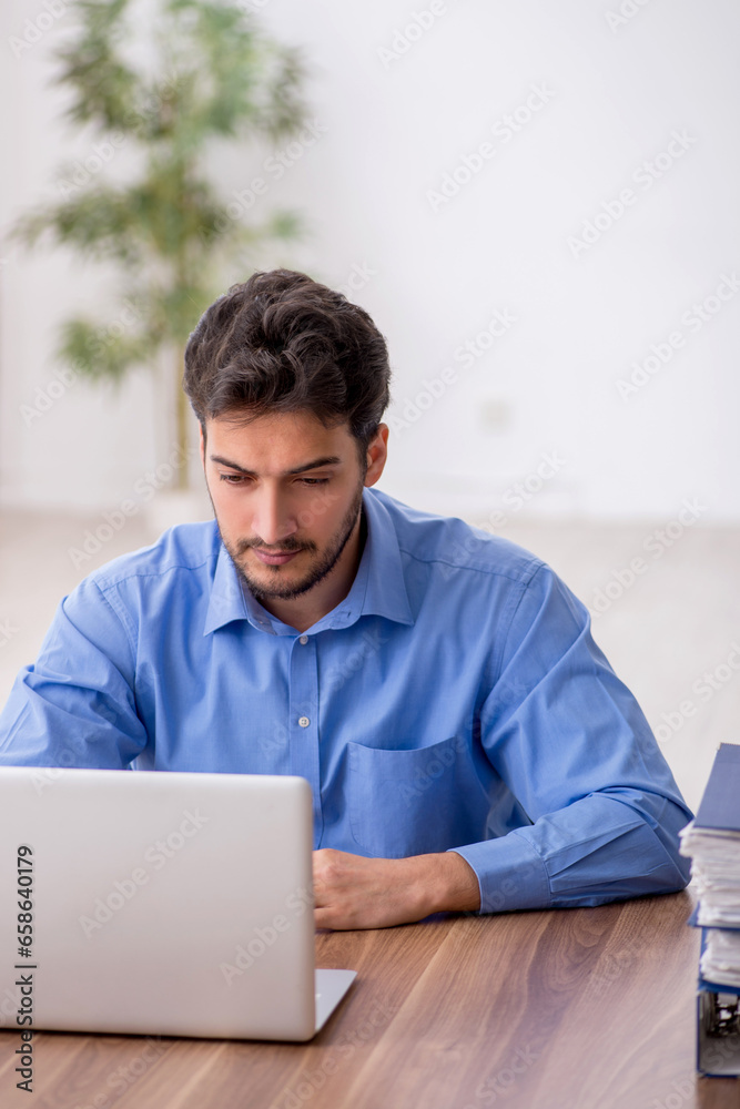 Young male employee working in the office Young male employee working in the office