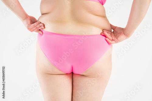 Overweight thigh, woman with fat hips and buttocks, obesity female body with cellulite on gray background