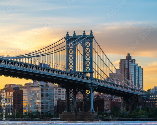 Manhattan bridge is a giant suspension bridge. .The public transport and vehicles drive on two levels. Connecting Brooklyn with Manhattan. Manhattan bridge is over on the East river In New york city